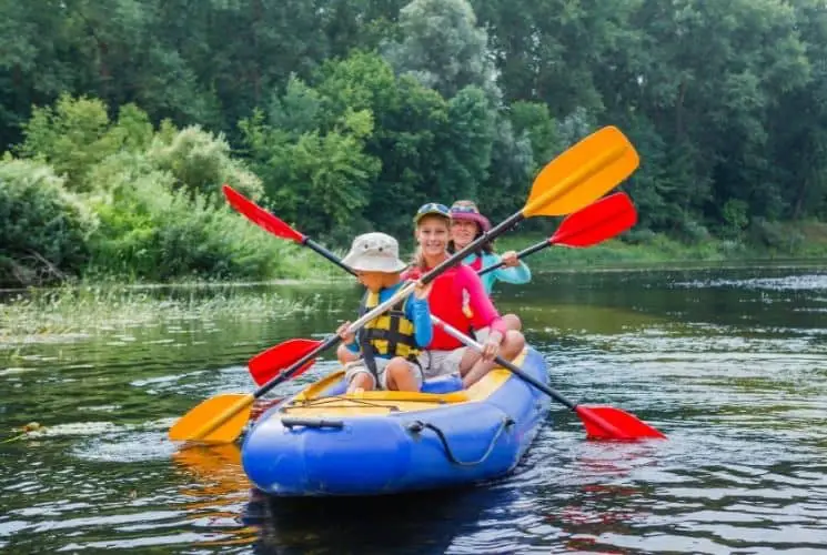 family kayaking in bright boat